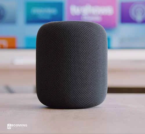 A dark grey portable Bluetooth speakers in the middle of a table