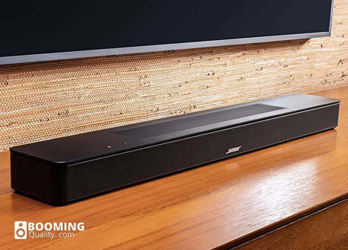 Bose black soundbar resting on a wooden cabinet